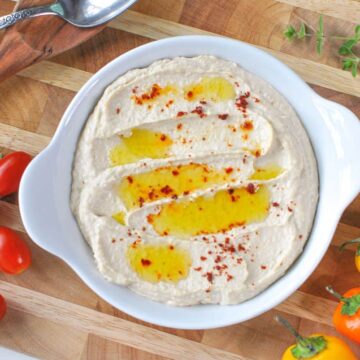 hummus on wood with peppers tomatoes