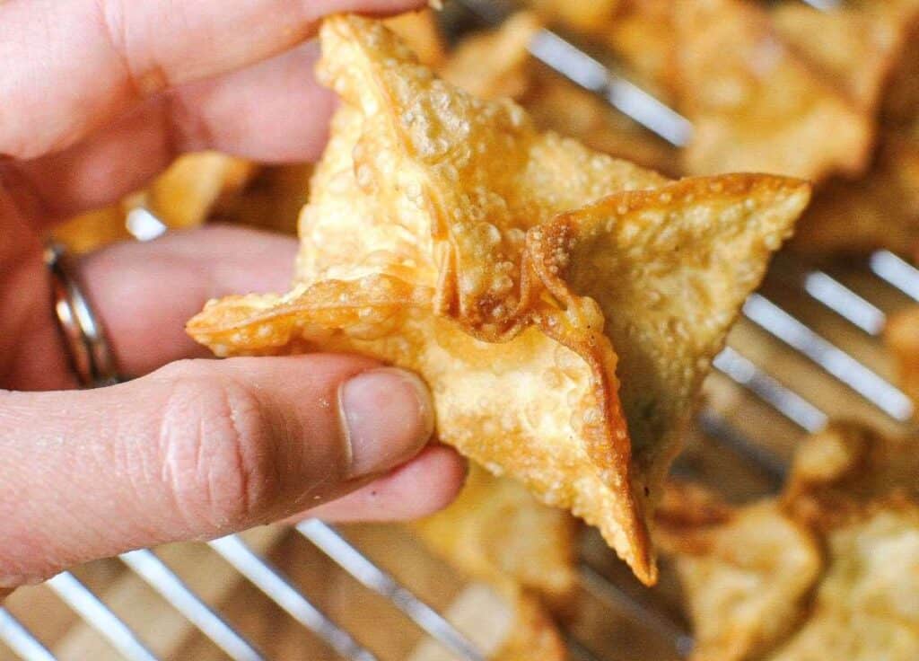 holding crab rangoon over cooling rack