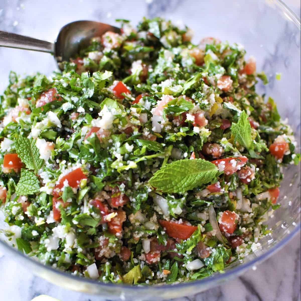 tabouli salad in glass bowl with parsley bulgur tomatoes mint onion lemon