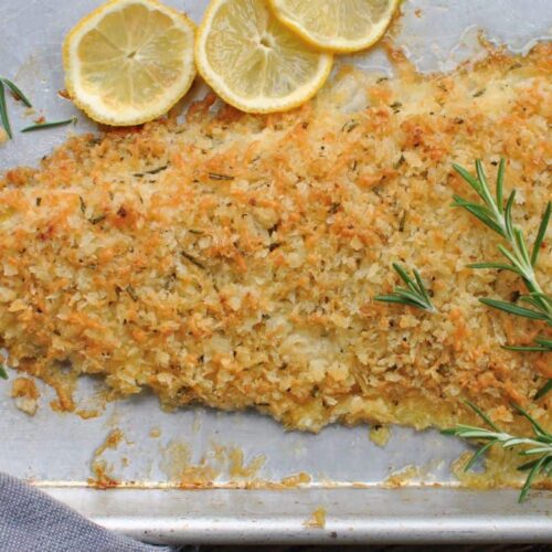 Fish crusted with parmesan rosemary recipe, crusted fish with sliced lemons rosemary on a baking sheet