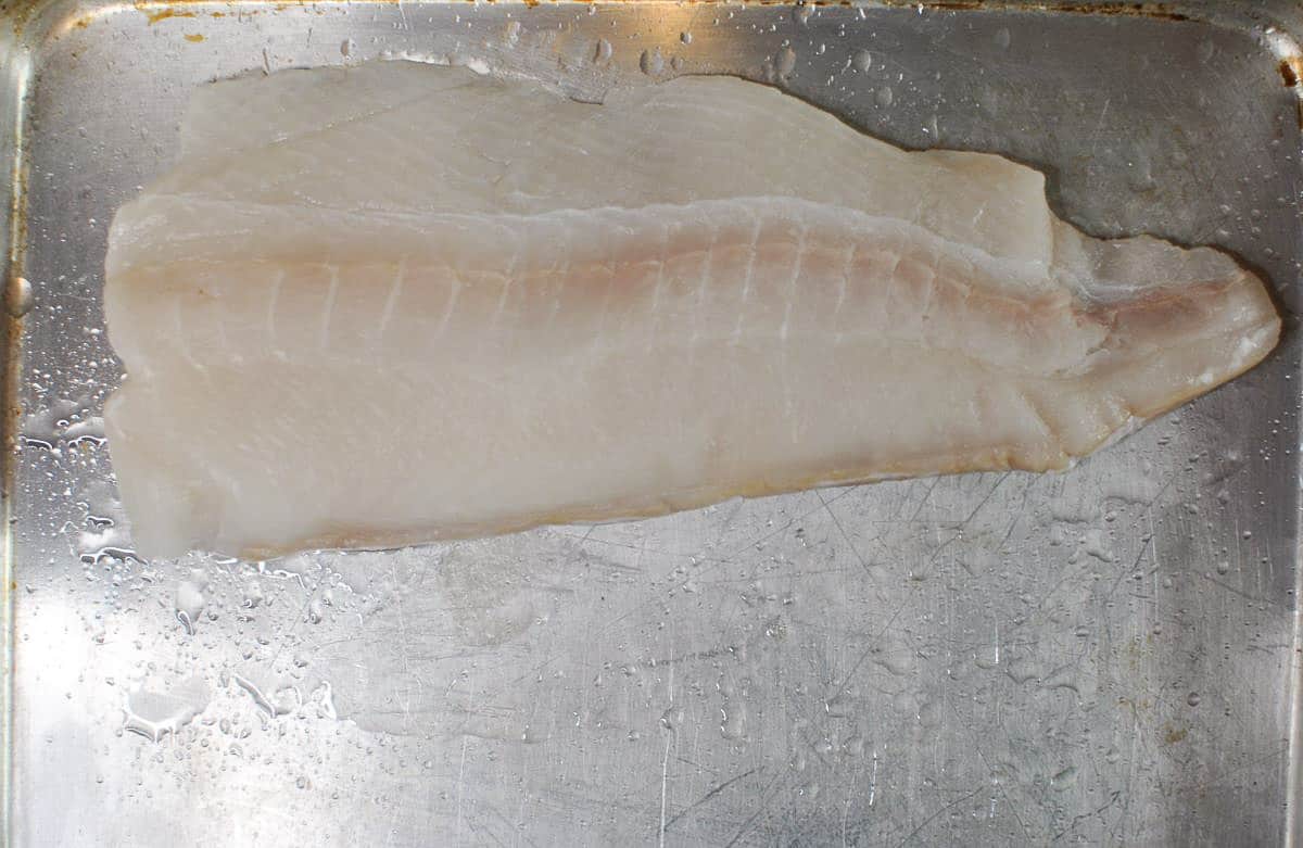 raw white fish fillet on sheet pan