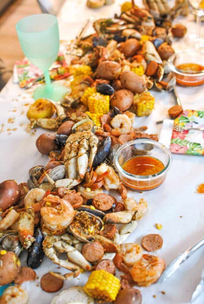 Seafood boil on table, crab, prawns, clams, mussels, corn, potatoes