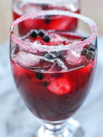sugar and salt rim with dark red alcoholic drink fresh huckleberry margarita