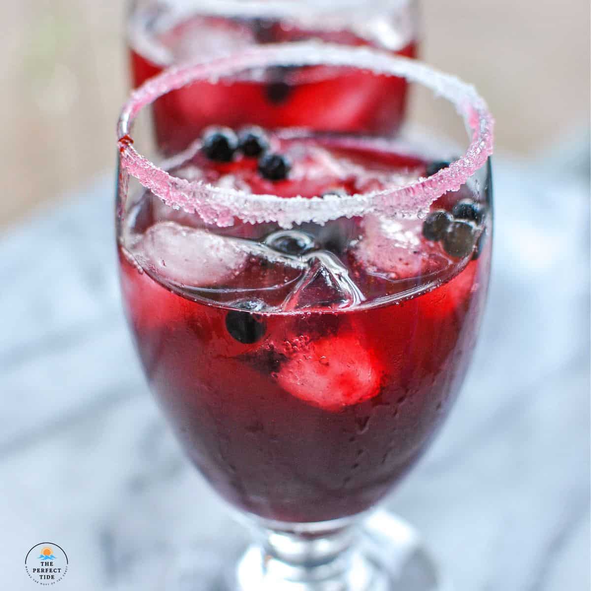 sugar and salt rim with dark red alcoholic drink fresh huckleberry margarita