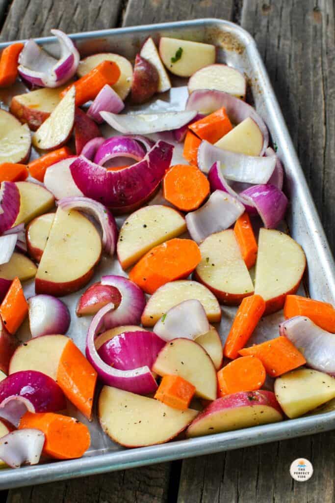 Roasted Root Vegetables on a sheet pan potatoes carrots red onion and radishes