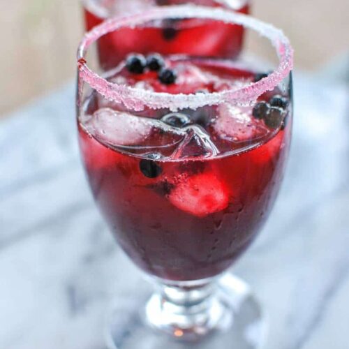 bright deep purple red huckleberry margarita alcoholic drink with fresh huckleberries