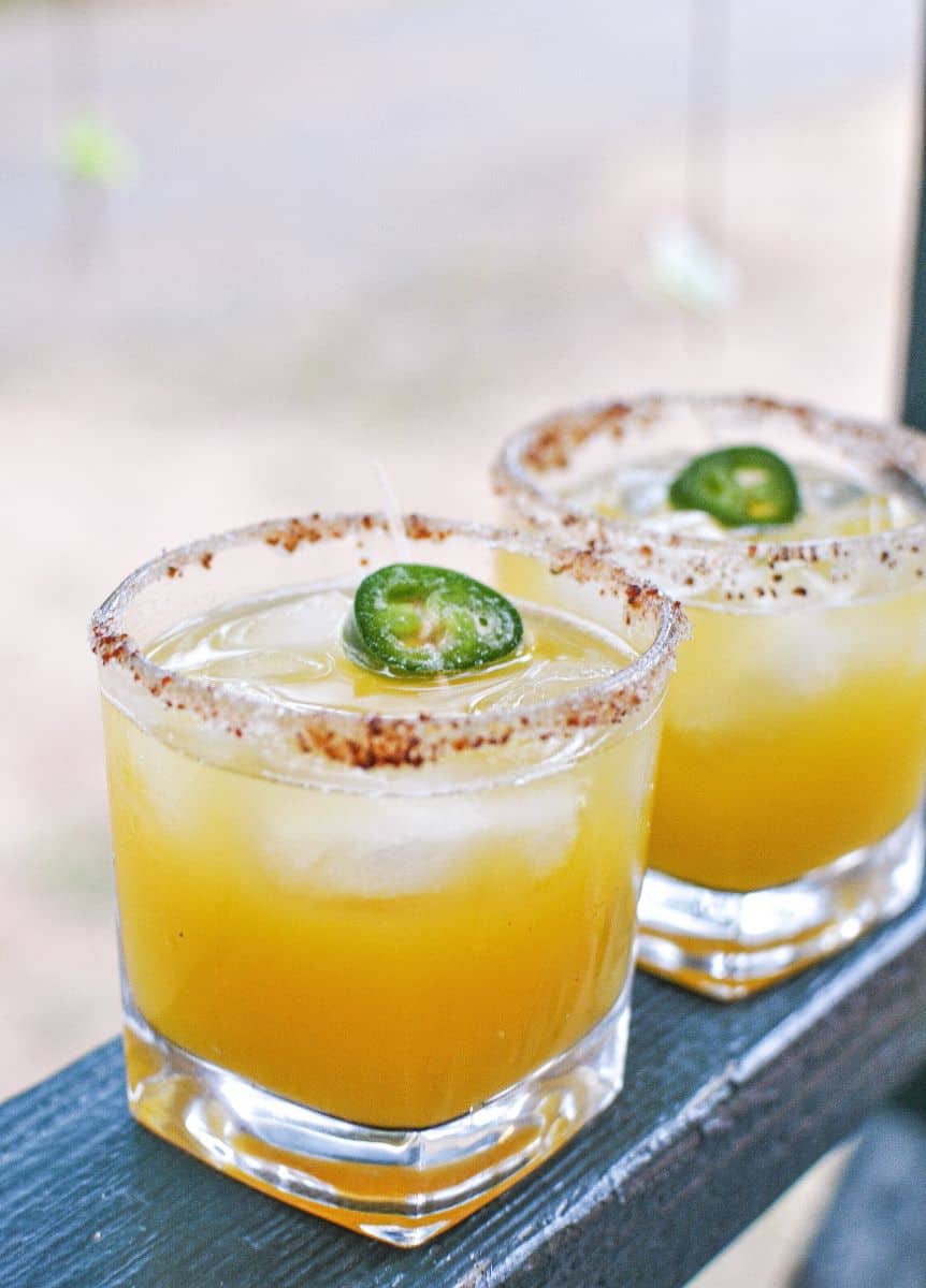 Mango Margarita on the rocks with jalapeno and tajin on the rim of the glass