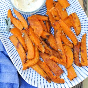 butternut squash fries with aioli on white and blue plate with blue napkin