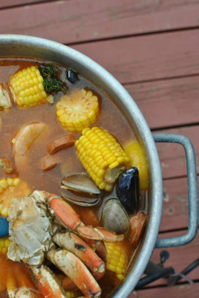 seafood oil in a pot with corn crab mussels prawns sausage