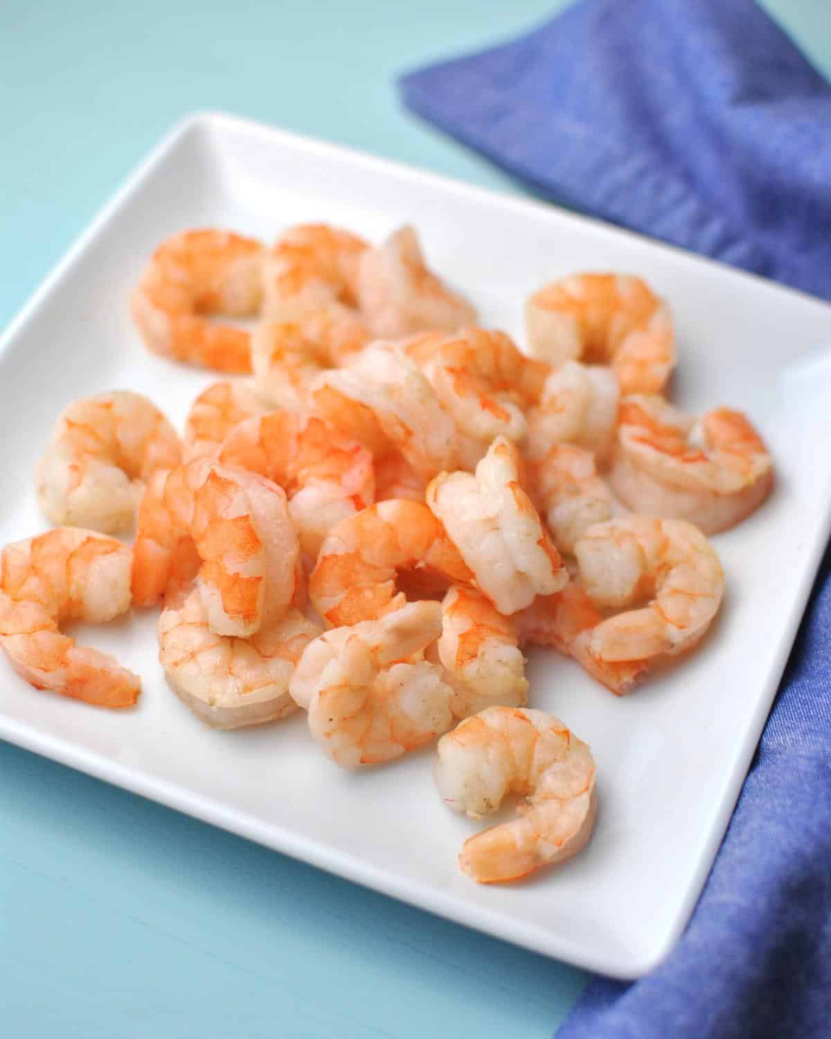 cooked shrimp plated with background of 2 shades of blue