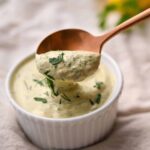 lemon herb tahini sauce in a white ramekin with copper spoon