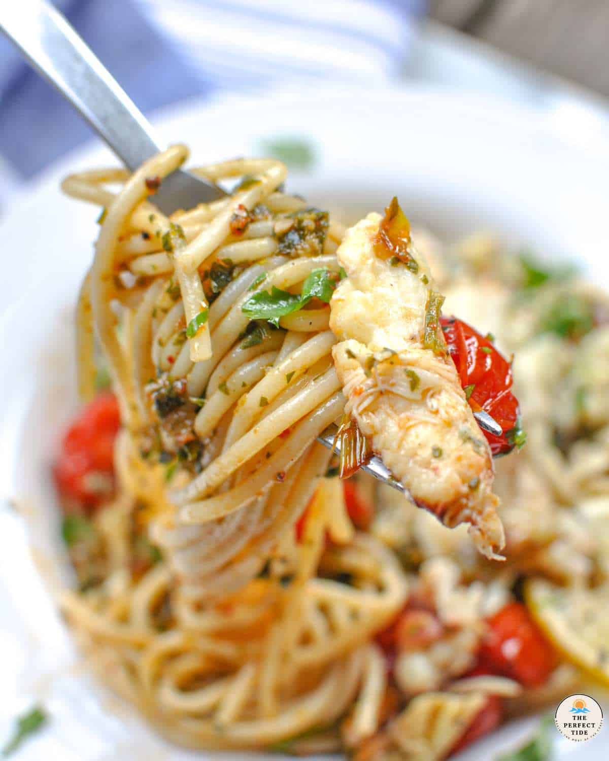 fork full of crab pasta with tomoatoes and lemon herb sauce