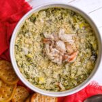 crab spinach artichoke dip topped with more crab served with crackers