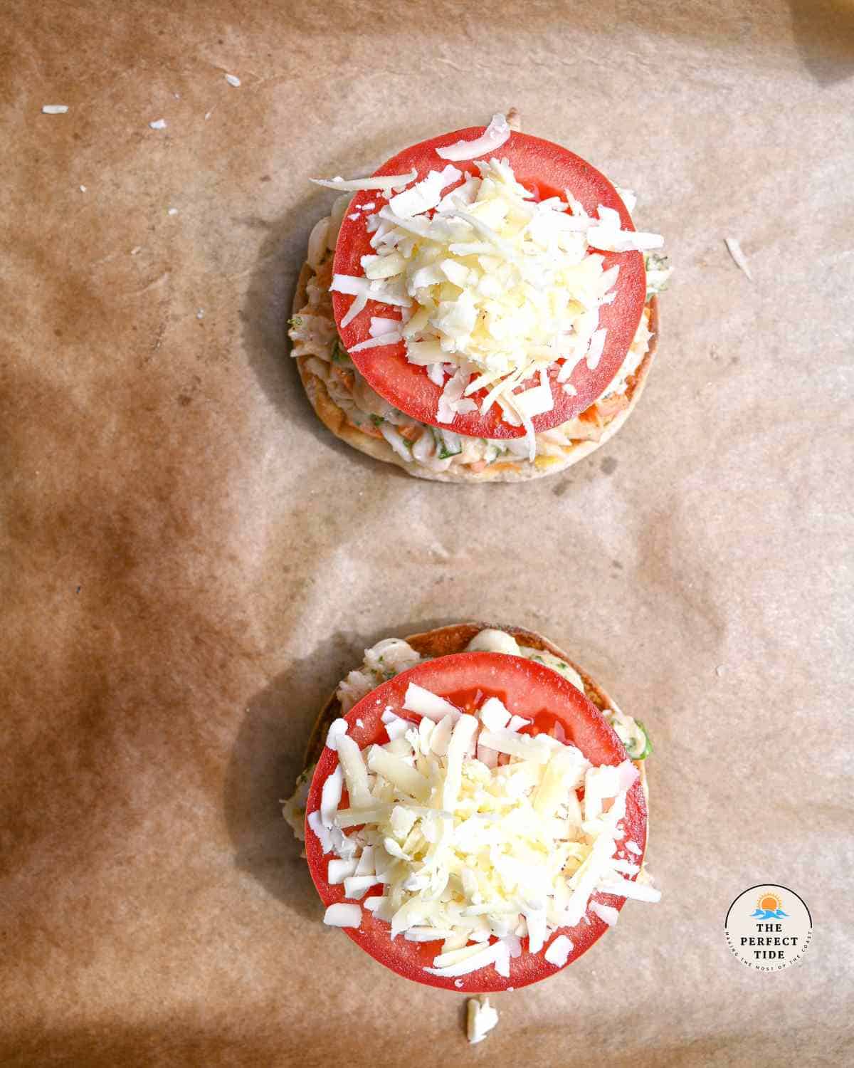 preparing the crab melts by adding crab salad tomato and cheese