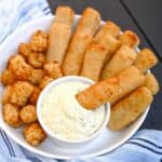 air fryer frozen fish fingers with tater tots and homemade tartar sauce in a ramekin