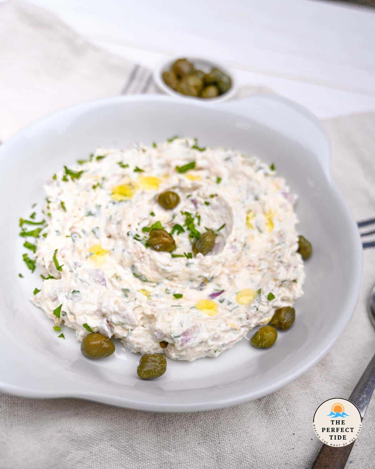 tuna dip in white plate with capers and parsley