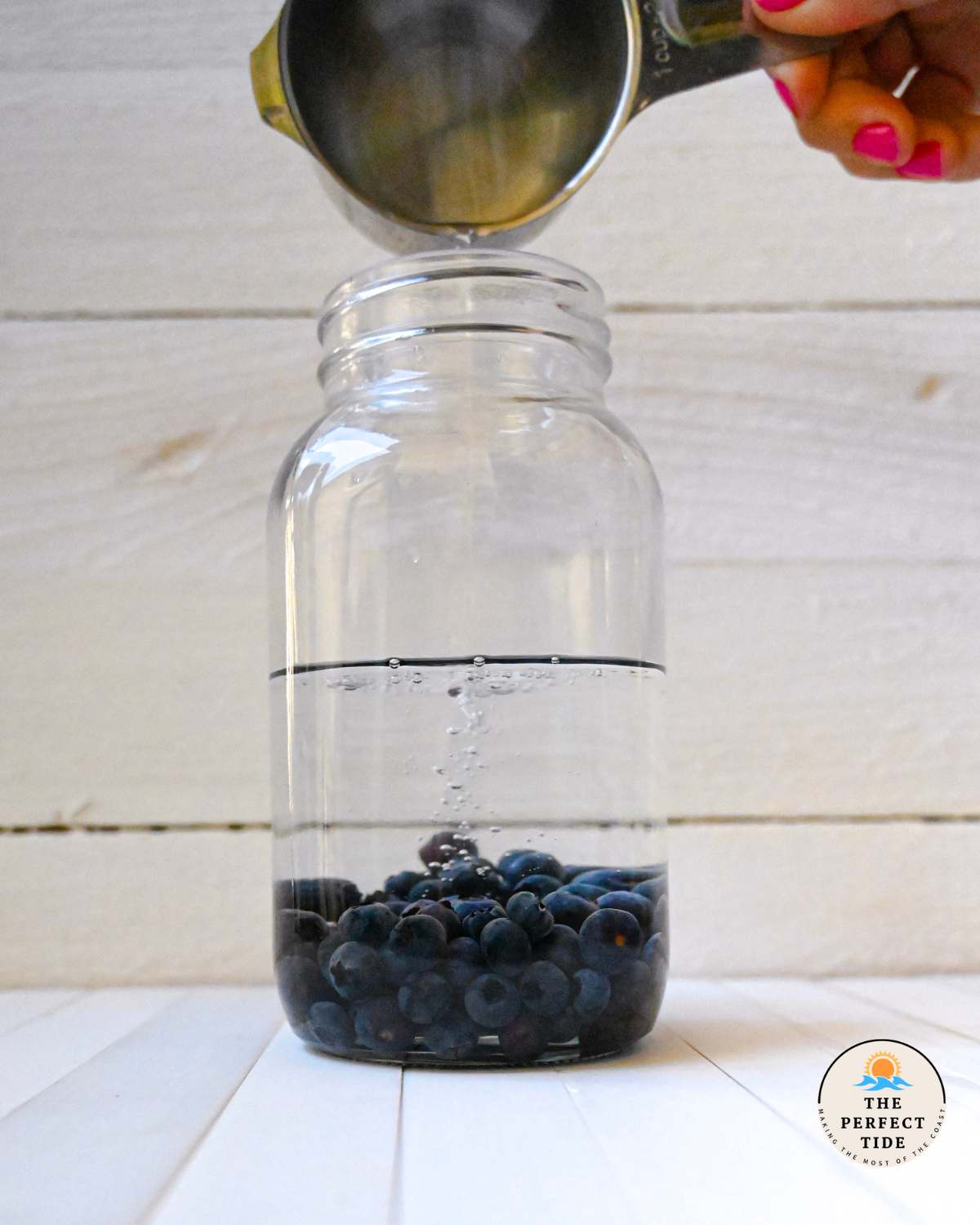 pouring vodka into blueberries