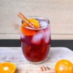 fall cocktail with gin and sweet vermouth cinnamon and orange slice garnish