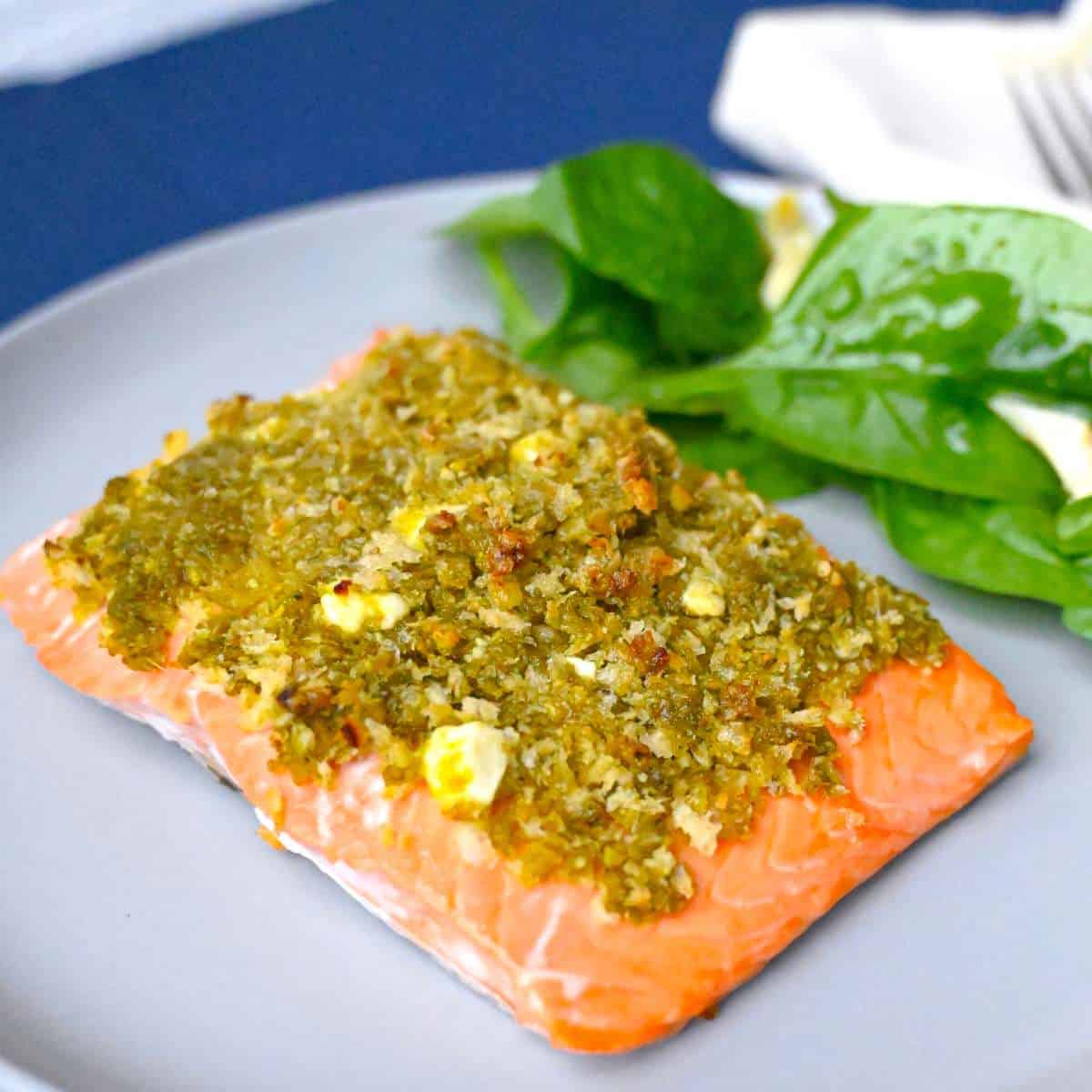 pesto crusted salmon on plate with spinach