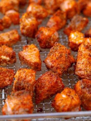 Golden crispy air fried salmon bites on a wire rack, ready to serve.