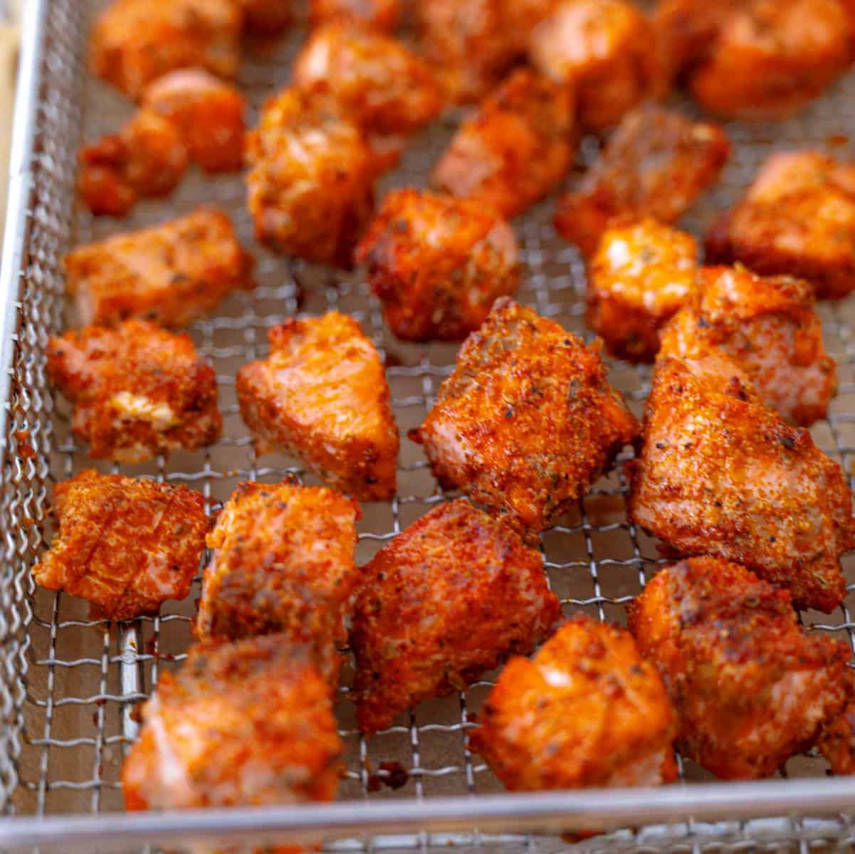 crispy salmon bites on an air fryer rack ready to serve.